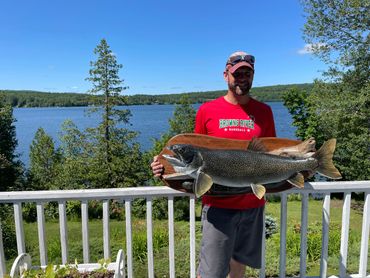 A man in red short holding a big fish