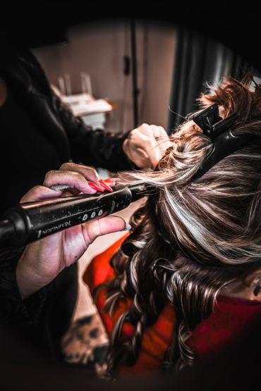 Close-up of hair curling with a flat iron and hair clip.
