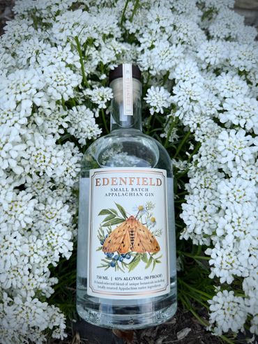 Edenfield Small Batch Appalachian Gin bottle surrounded by white flowers.