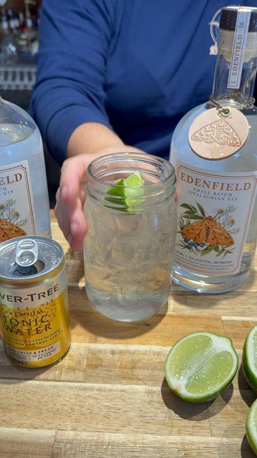 A refreshing gin and tonic with lime in a mason jar.