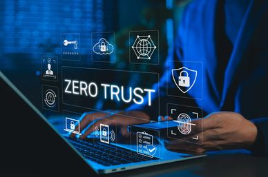 Concept of Zero Trust cybersecurity with digital icons and a person using laptop and smartphone.