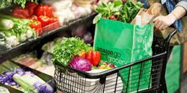 Shopping cart filled with fresh groceries in a supermarket aisle.