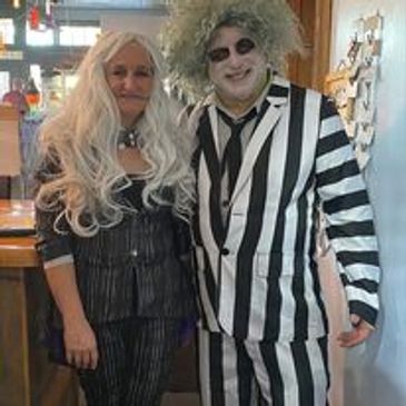 Two people dressed in Beetlejuice-themed costumes.