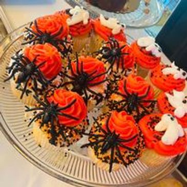 Halloween themed cupcakes with spider and ghost decorations.