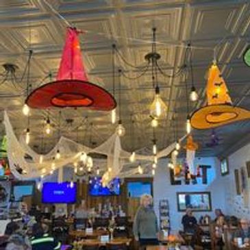 Halloween-themed restaurant interior with witch hats and hanging decorations.
