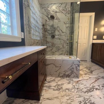 Luxurious bathroom with marble flooring and shower walls, dark wood cabinets, and a white countertop.