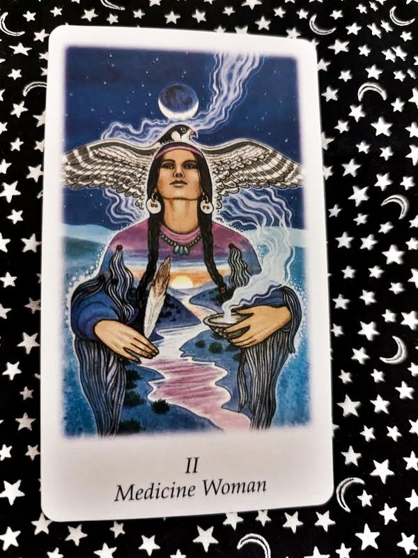 Tarot card of the Medicine Woman with spiritual imagery and nature elements.