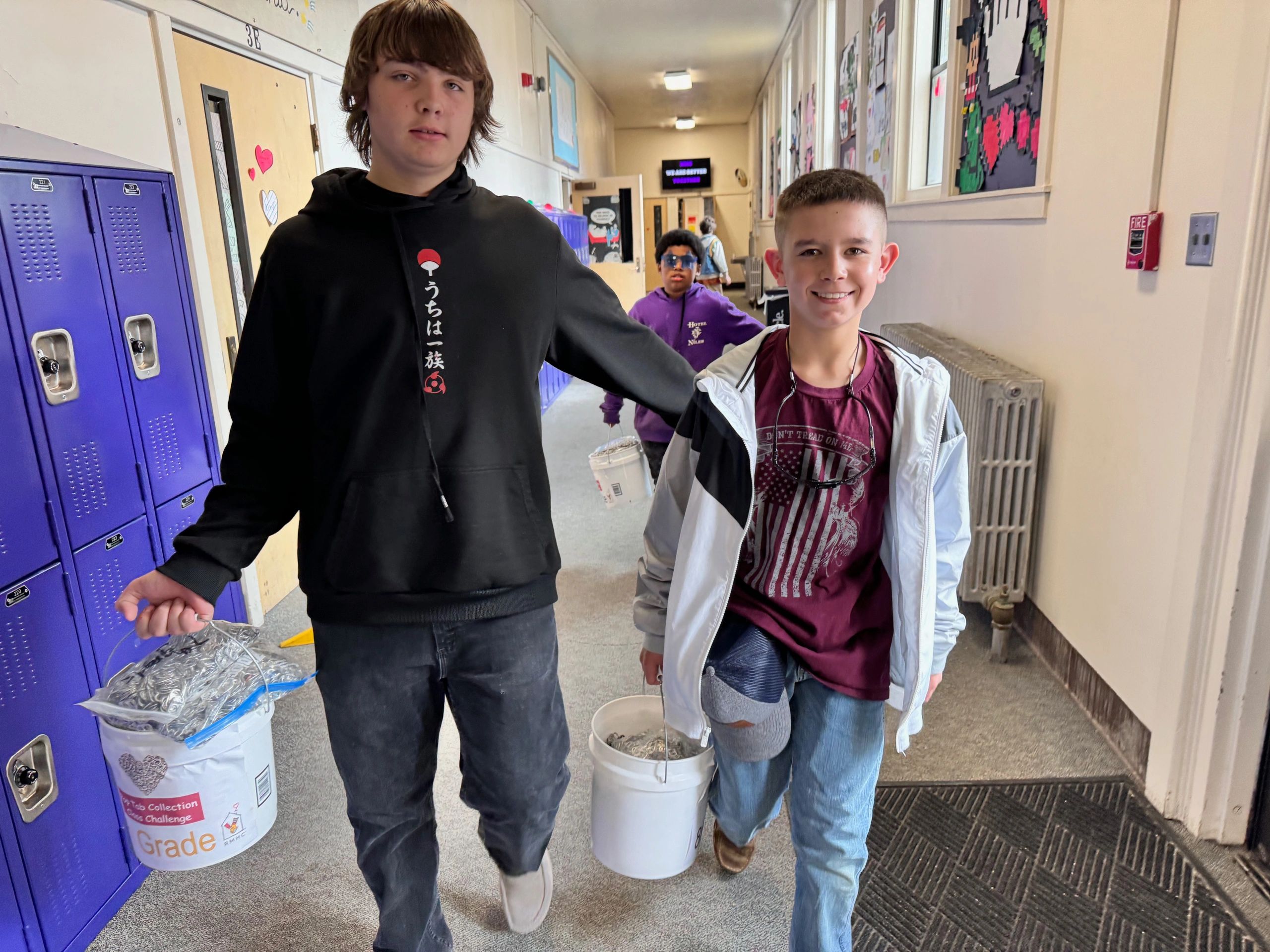 Interact students carrying 29,600 (18.5 lbs.) pop tabs collected from a school-wide contest.  