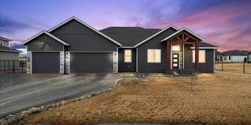 Modern single-story house with dark exterior and three-car garage at dusk.