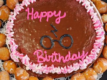 Chocolate birthday cake with Harry Potter glasses and lightning bolt design.