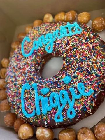 Giant sprinkle-covered donut with "Congrats Chiggie" in blue icing.