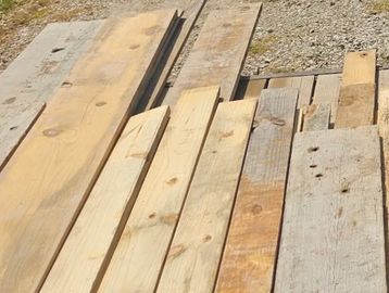 Various wooden planks laid out on the ground outdoors.