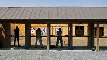 Stack of books next to pencils in a holder and a camera.