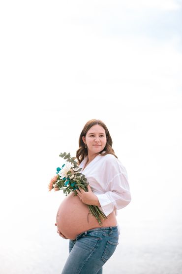 Maternity photo, blue jeans and white top with flowers. Maternity photos take in the GTA