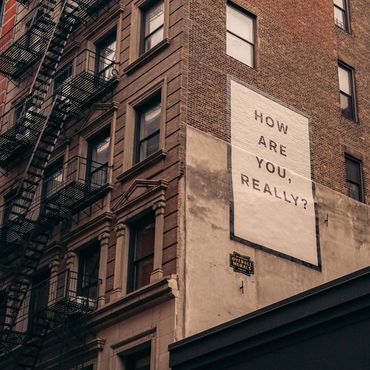 Side of Building/Street Art saying: "How are you, really?" Photo by Finn on Unsplash