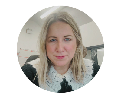 Woman with blonde hair and blue eyes wearing a black and white lace-collared sweater.