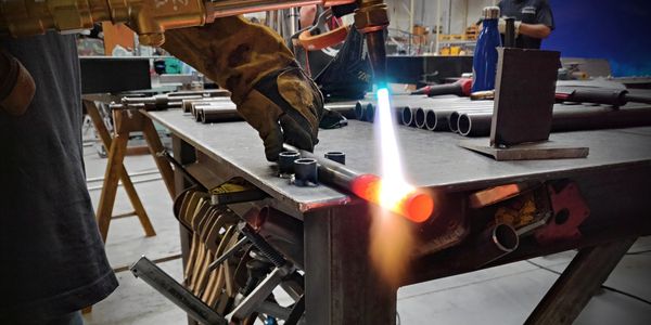 Using a torch to heat up a solid steel bar to be bent into a custom radius.