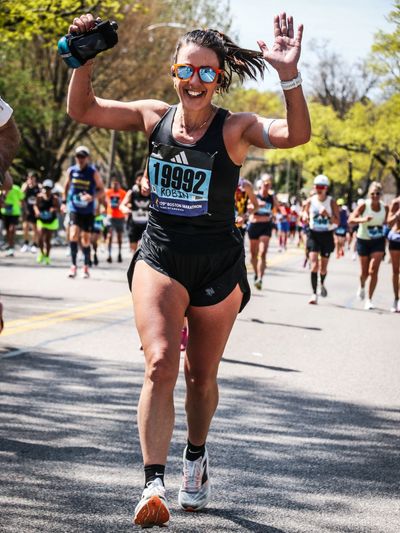 Smiling female runner celebrating during a marathon.