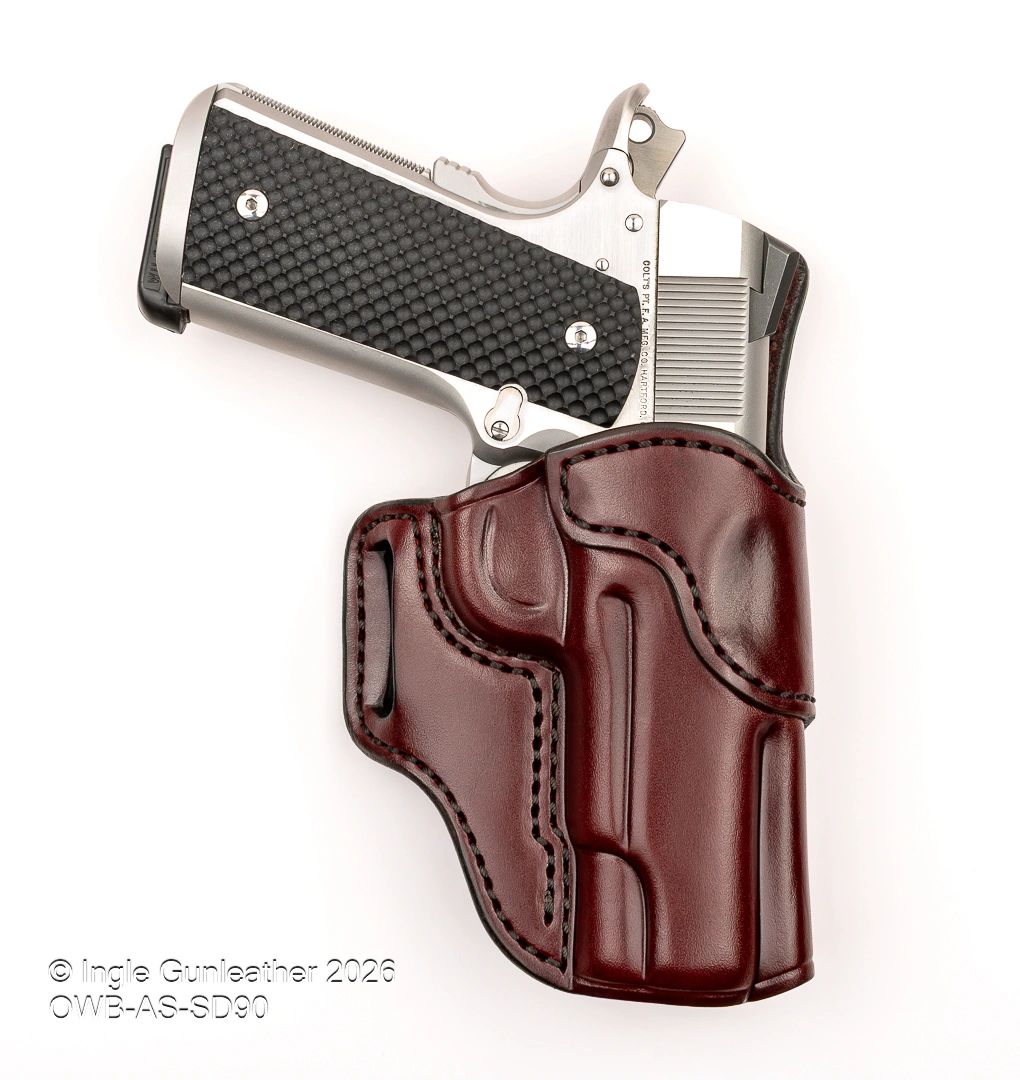 Compact handgun in a polished brown leather holster on white background.