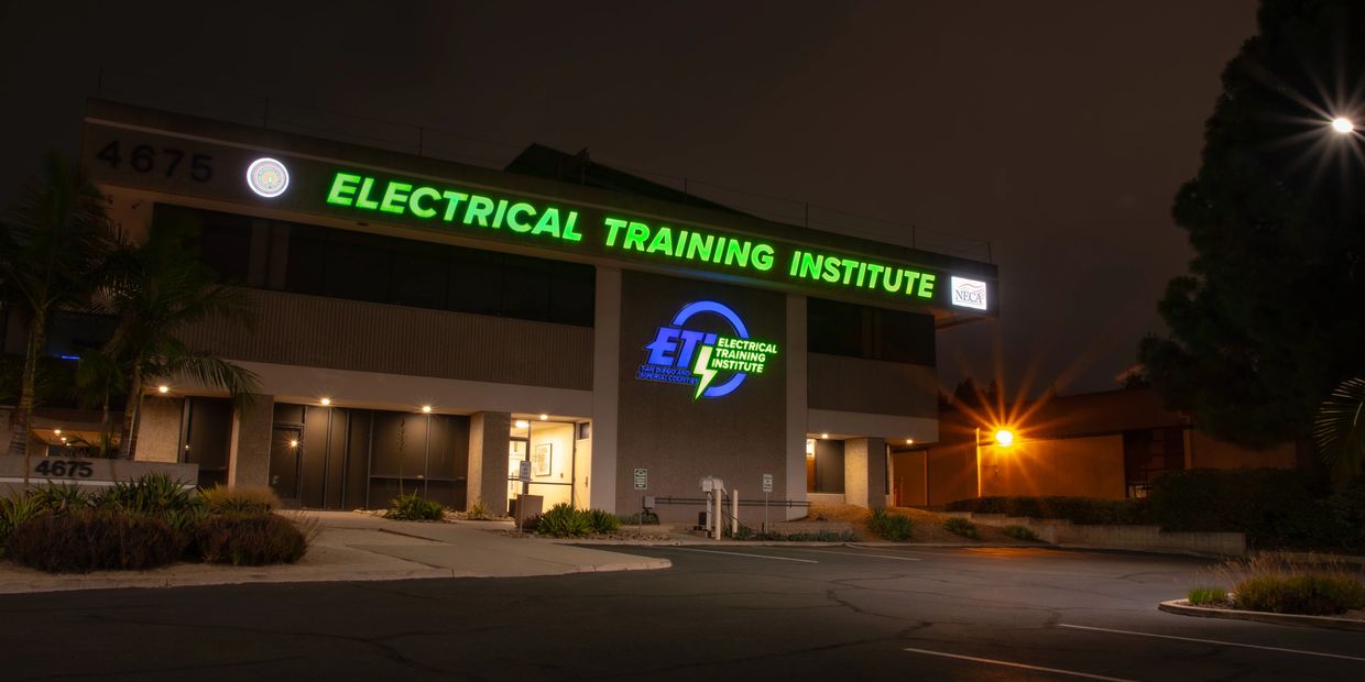 Night view of the Electrical Training Institute building with illuminated signage.