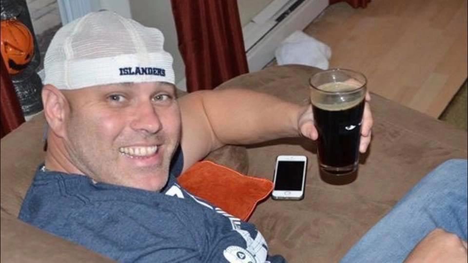 Detective Brian "Smiles" Simonsen smiling and holding a glass