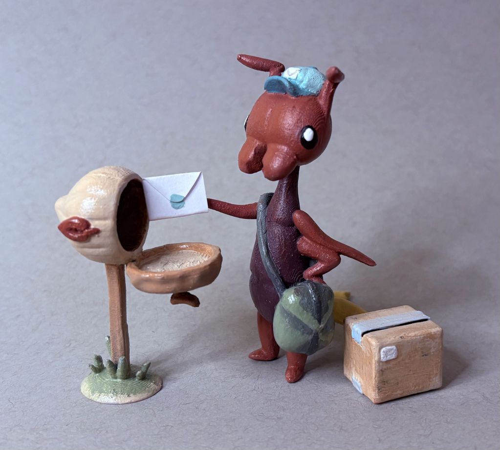 A figurine of an earwig mailman, a mailbox, and a package for him to deliver.
