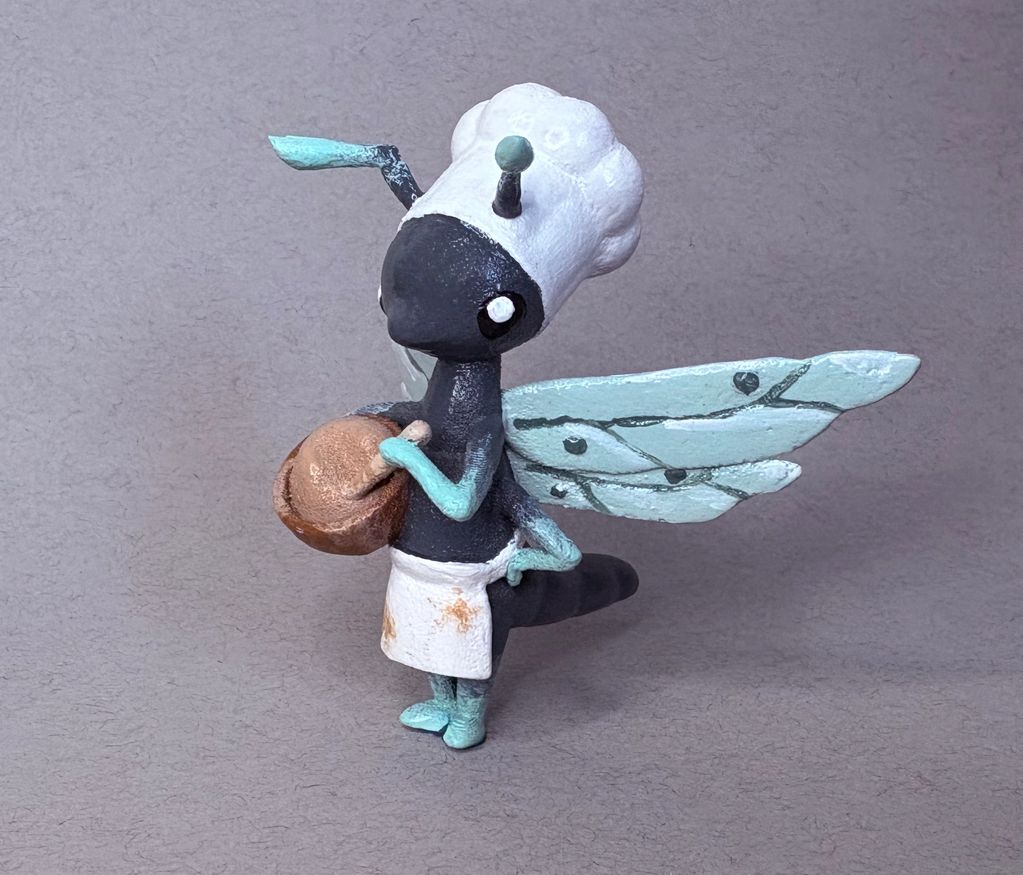 A figurine of a dragonfly pastry chef.