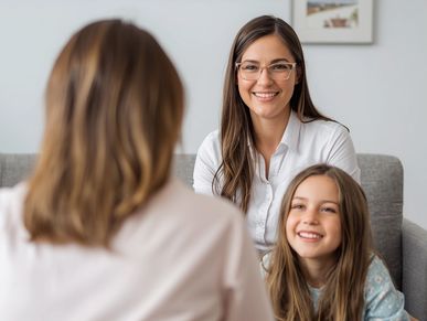 Woman and child smiling during a conversation with another person.