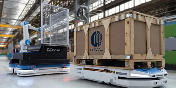 Automated robots transporting goods in a warehouse with COMAU branding.