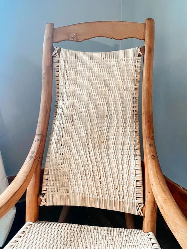 Close up of new caning on repaired wooden rocking chair.