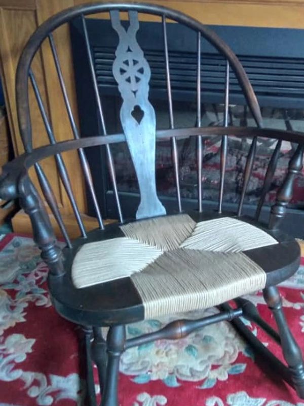 image of repaired seat in front of a fire place on a red woven rug.