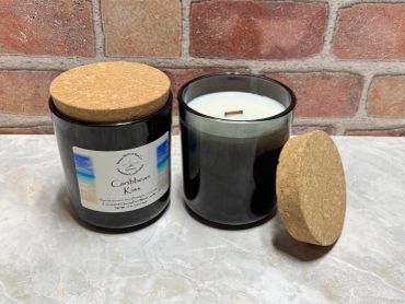 Two black candles with cork lids against a brick wall.