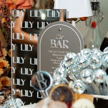 Bar sign with decorative items and metallic sticks.