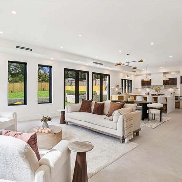 Bright, modern open living space with neutral tones and large windows.