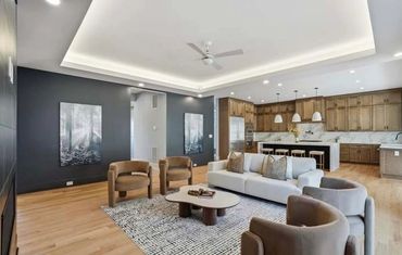 Modern open living room with neutral tones and wooden flooring.