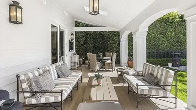 Cozy outdoor patio with striped cushioned seating and dining area under a covered porch.