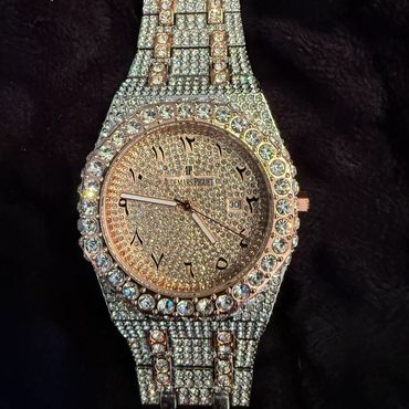 Luxurious Audemars Piguet watch encrusted with diamonds and Arabic numerals.