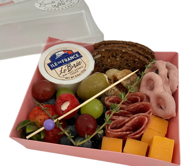 A small charcuterie box with cheese, crackers, fruits, and meats.