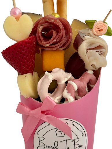Edible charcuterie bouquet with meats, cheeses, and sweets.