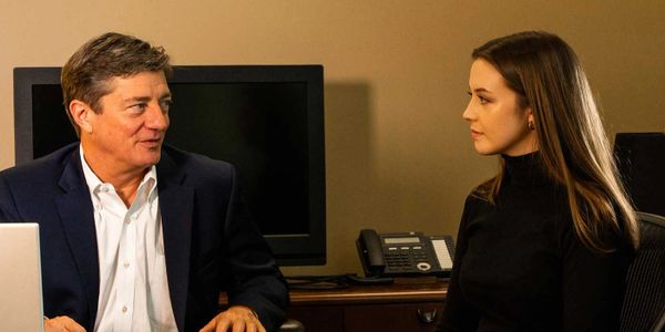 Two colleagues engaged in a serious office discussion.
