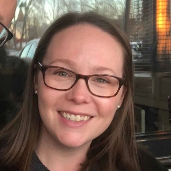 Close-up of a smiling woman with glasses.