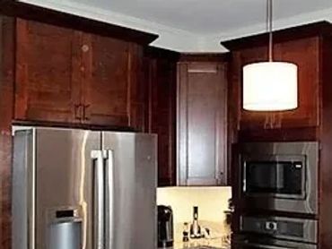 Kitchen remodel with dark wood cabinets, stainless appliances, and quartz countertops.