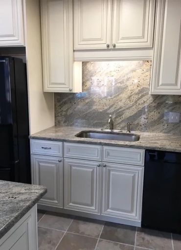 Kitchen remodel with cream cabinets, granite countertops, and full backsplash wall.