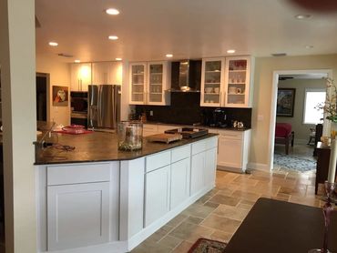 Kitchen remodel with large island, glass cabinet doors, and stainless appliances.