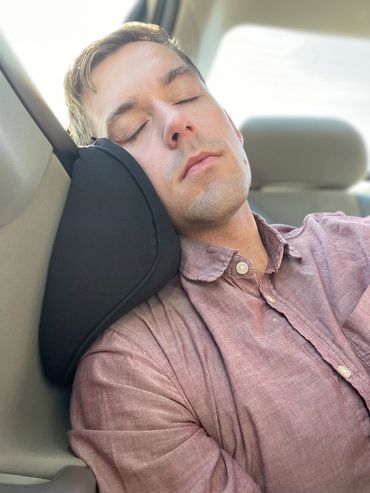 Man sleeping on an Arto Pillow - Memory Foam while in a car.