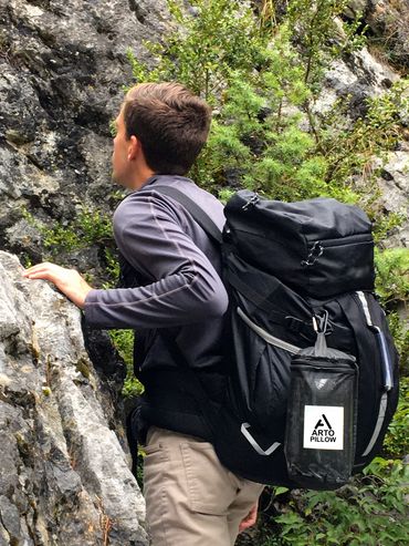Arto Pillow - Memory Foam + in its carrying case, attached to a rucksack while mountain climbing.