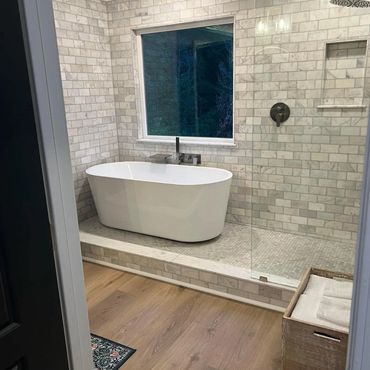 Modern bathroom with freestanding tub and marble tiles.