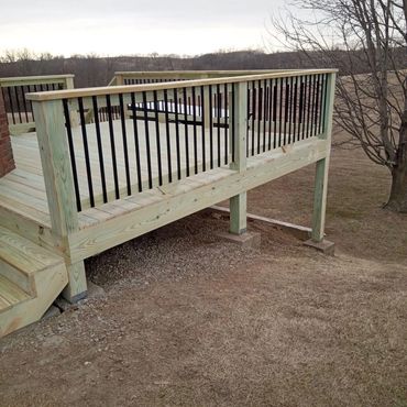 Newly built wooden deck with black railings.