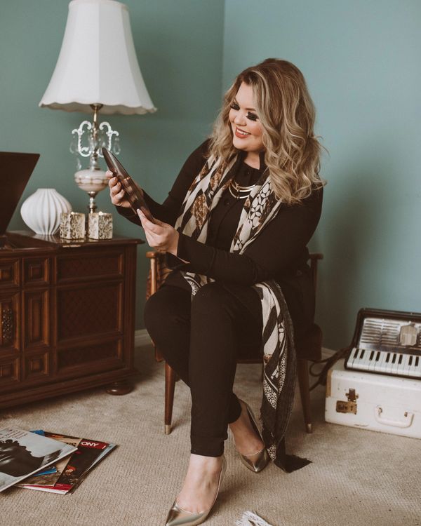 Jayme Giesbrecht blonde hair holding a record in her hands. Sitting by 1970's record player.