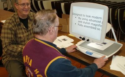 Center Founder Carl Corbin tries out CCTV reading machine